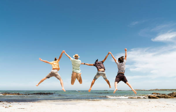 Four people jumping in the air on a beach